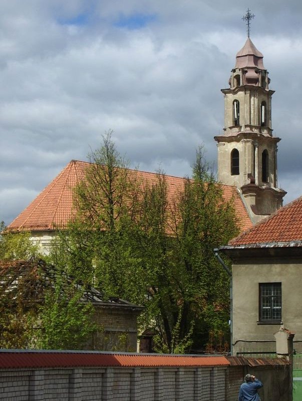 Zdjęcie kolorowe. Przedstawia fragment kościoła i ceglany mur. Jest to Kościół Augustianów w Wilnie. 