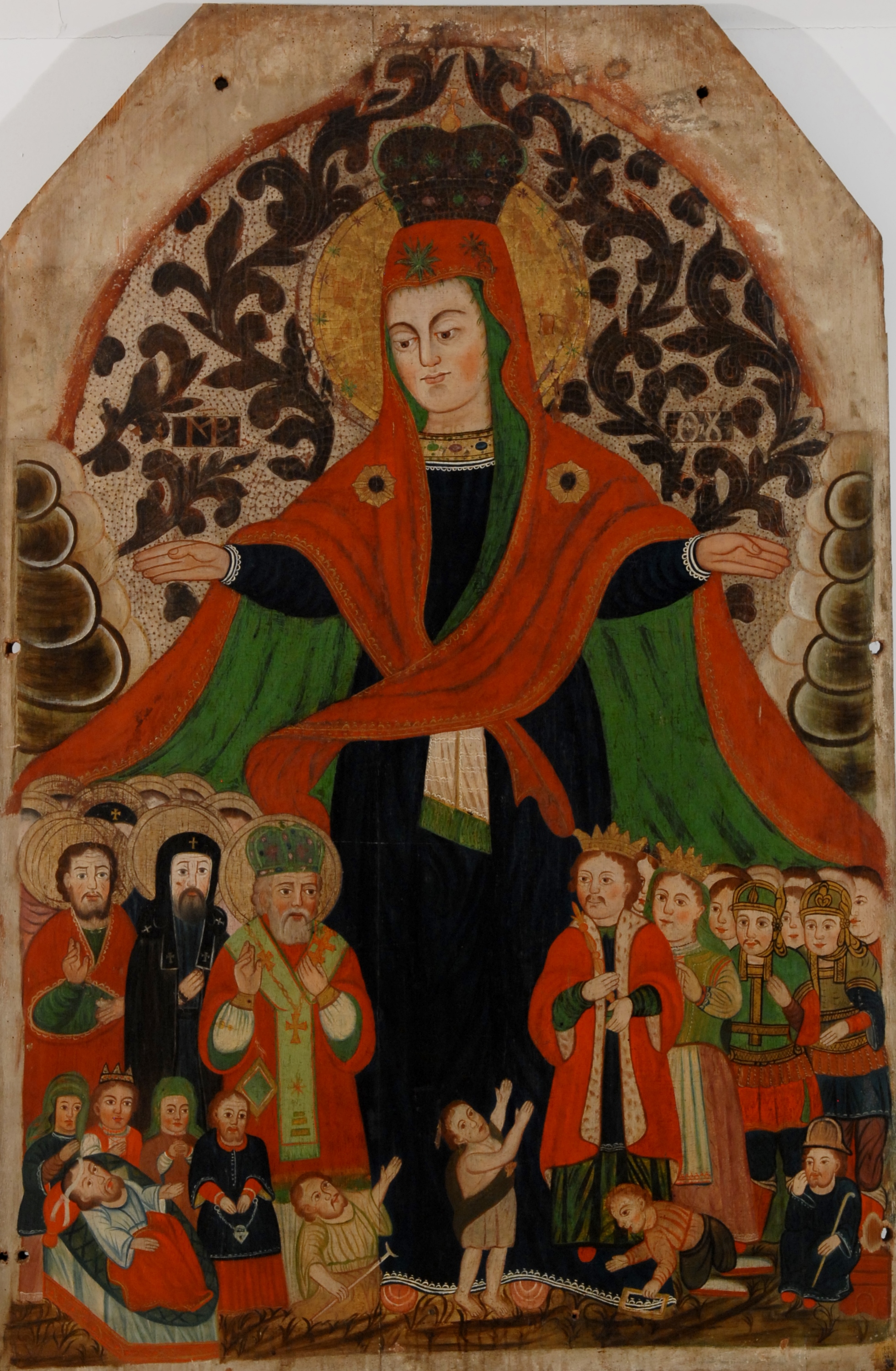Tempera na desce. Obraz przedstawia wizerunek Matki Boskiej Opieki. Matka Boska w koronie na głowie, ukazana w czarnej sukni i czerwonym płaszczu poszytym zielonym płótnem. Maria rozpościera nad wierzącymi płaszcz ochronny. Wśród chroniących się pod płaszczem Marii, na czele grupy po prawej stronie kompozycji, widoczna jest para królewska, którą możemy identyfikować z Janem III Sobieskim i Marią Kazimierą. 