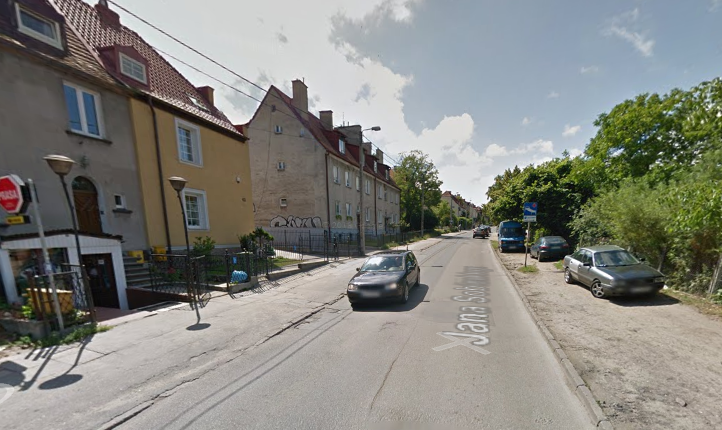 Współczesne zdjęcie. Przedstawia widok na ulicę wraz z zabudowaniami miejskimi. Jest to Ulica Jana Sobieskiego w Gdańsku.