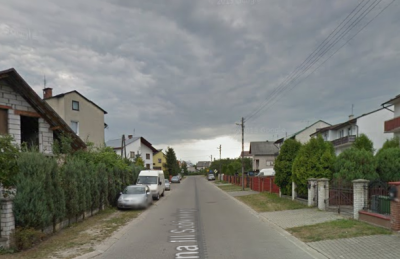 Współczesne zdjęcie. Przedstawia ulicę i zabudowania. Jest to ulica Jana III Sobieskiego w Biłgoraju. 