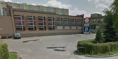 Współczesne zdjęcie. Przedstawia widok na niski budynek szkoły, za nim wysoki blok. Jest to Szkoła Podstawowa nr 15 im. Jana III Sobieskiego w Poznaniu. 