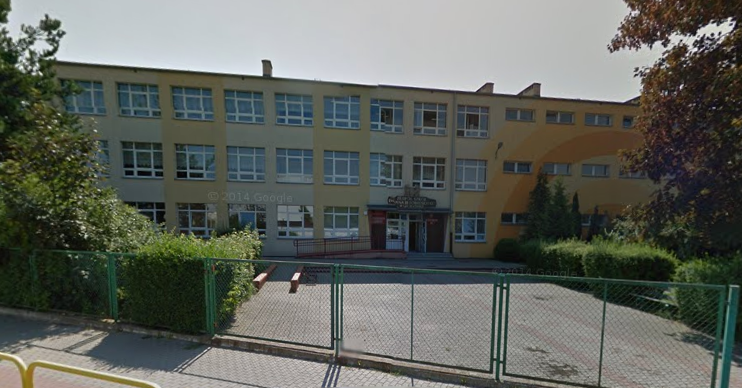 Współczesne zdjęcie. Przedstawia widok na budynek z wejściem, przed nim ogrodzenie. Jest to Zespół szkół im. Jana III Sobieskiego w Szczecinku. 