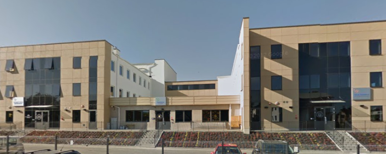 Współczesne zdjęcie. Przedstawia widok na fasadę nowoczesnego, niskiego budynku. Jest to Gimnazjum i Liceum Ogólnokształcące im. Jana III Sobieskiego w Lublinie. 