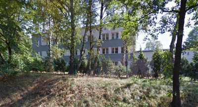 Współczesne zdjęcie. Przedstawia budynek za ogrodzeniem. Jest to Szkoła podstawowa im. Jana III Sobieskiego w Lyskach. 