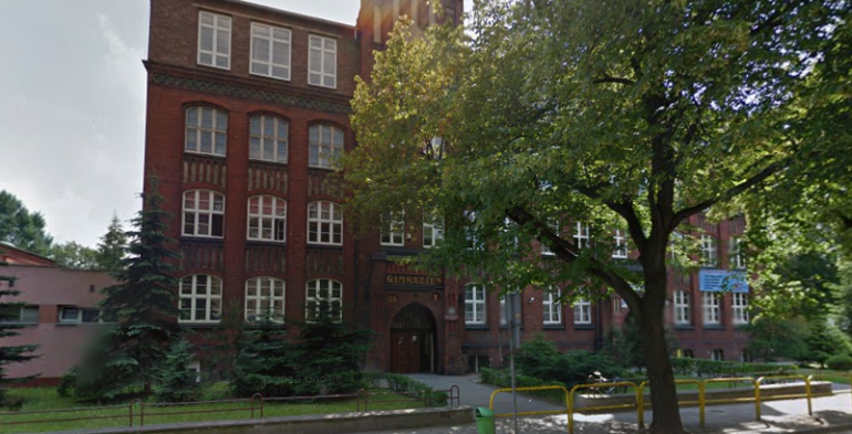 Współczesne zdjęcie. Przedstawia widok na zabytkowy budynek z czerwonej cegły. Jest to Publiczne Gimnazjum nr 1 im. Jana III Sobieskiego w Tarnowskich Górach. 