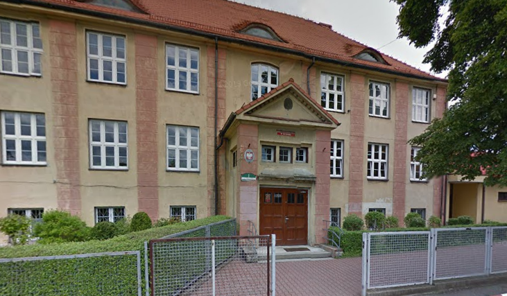 Współczesne zdjęcie. Przedstawia widok na stary budynek, przed którym stoi ogrodzenie. Jest to Szkoła Podstawowa nr 38 im. Jana III Sobieskiego w Bytomiu. 