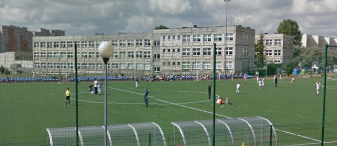 Współczesne zdjęcie. Przedstawia widok na boisko sportowe i budynek szkoły w tle. Jest to Gimnazjum nr 1 im. Jana III Sobieskiego w Częstochowie. 