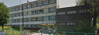 Współczesne zdjęcie. Przedstawia widok na długi budynek z wejściem, obok szara dobódówka. Jest to Zespół Szkół nr 6 im. Króla Jana III Sobieskiego w Jastrzębiu-Zdroju. 