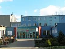 Współczesne zdjęcie. Przedstawia widok na błękitny budynek, przed którym stoi ogrodzenie. Jest to Technikum nr 6 im. Jana III Sobieskiego w Jaworznie. 