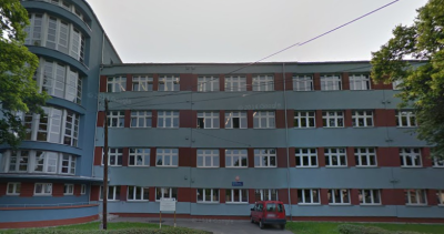 Współczesne zdjęcie. Przedstawia widok na fasadę współczesnego budynku szkoły. Jest to I Liceum Ogólnokształcące im. Króla Jana III Sobieskiego w Piekarach Śląskich. 