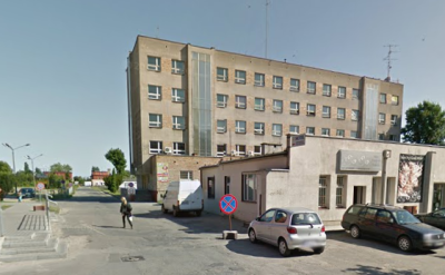 Współczesne zdjęcie. Przedstawia widok na kilkupiętrowy budynek z wejściem, przed nim niska dobódówka. Jest to Zespół Szkół im. Jana III Sobieskiego w Gnieźnie.