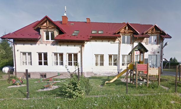 Współczesne zdjęcie. Przedstawia widok na remontowany niski budynek. Przed szkołą plac zabaw. Jest to Publiczna Szkoła Podstawowa im. Jana III Sobieskiego w Czułówku. 