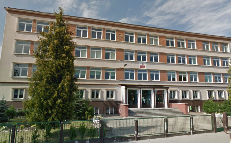 Współczesne zdjęcie. Przedstawia widok na odnowiony budynek i wejście. Przed szkołą ogrodzenie. Jest to Szkoła Podstawowa nr 2 im. Jakuba Sobieskiego w Oławie. 