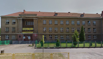 Współczesne zdjęcie. Przedstawia widok na budynek z wejściem, przed nim ogrodzenie. Jest to Zespół Szkól nr 12 im. Jana III Sobieskiego w Gorzowie Wielkopolskim. 