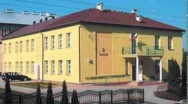 Współczesne zdjęcie. Przedstawia widok na żółty budynek z brązowym dachem, przed którym stoi ogrodzenie. Jest to Szkoła Podstawowa im. Jana III Sobieskiego w Płonce Kościelnej. 