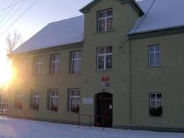 Współczesne zdjęcie. Przedstawia widok na wejście do budynku szkolnego. Jest to Publiczna Szkoła Podstawowa z Oddziałem Przedszkolnym im. Jana III Sobieskiego w Pilszczu. 