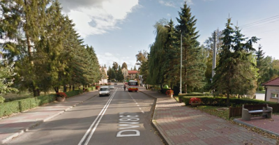 Współczesne zdjęcie. Przedstawia widok ulicy w mieście. Po prawej stronie pojedyncze budynki, po lewej drzewa i trawnik. Jest to Ulica Sobieskiego w Horyńcu-Zdroju. 