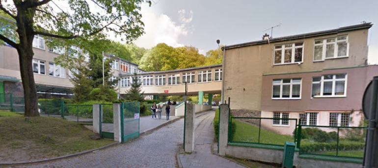 Współczesne zdjęcie. Przedstawia widok na wejście i budynek szkoły. Jest to Gimnazjum nr 26 im. Jana III Sobieskiego w Gdańsku. 