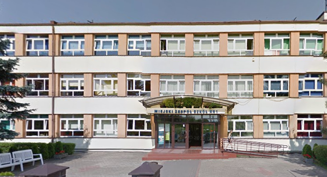 Współczesne zdjęcie. Przedstawia widok na długi budynek z wejściem. Jest to Szkoła Podstawowa nr 2 im. Jana III Sobieskiego w Będzinie. 