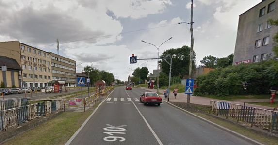 Współczesne zdjęcie. Przedstawia widok na ulicę i zabudowania miejskie. Jest to ulica Jana III Sobieskiego w Dąbrowie Górniczej. 