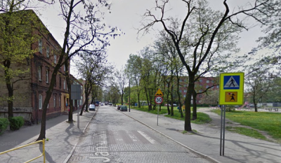 Współczesne zdjęcie. Przedstawia widok na ulicę wraz z zabudowaniami miejskimi. Jest to Ulica Jana III Sobieskiego w Zabrzu. 