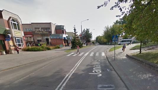 Współczesne zdjęcie. Przedstawia widok na ulicę z zabudowaniami przy drodze. Jest to ulica Jana III Sobieskiego w Iławie. 