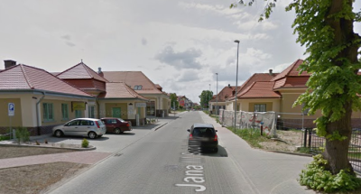 Współczesne zdjęcie. Przedstawia widok na ulicę wraz z zabudowaniami. Jest to Ulica Jana III Sobieskiego w Ostródzie. 