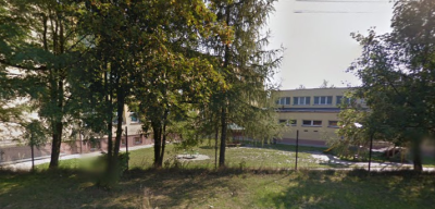 Współczesne zdjęcie. Przedstawia widok niski budynek ukryty za drzewami. Jest to Szkoła Podstawowa im. Króla Jana III Sobieskiego w Przegini. 