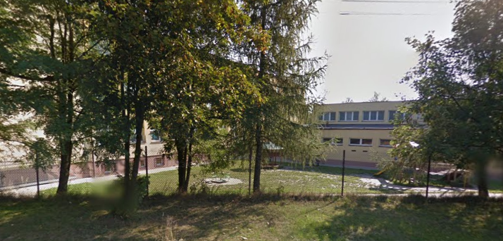 Współczesne zdjęcie. Przedstawia widok niski budynek ukryty za drzewami. Jest to Szkoła Podstawowa im. Króla Jana III Sobieskiego w Przegini. 