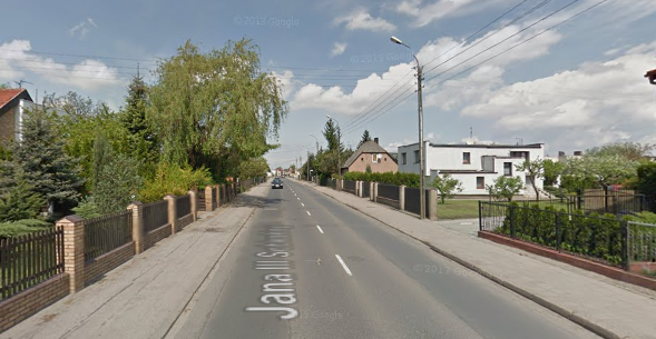 Współczesne zdjęcie. Przedstawia widok na ulicę. Po prawej i lewej stronie zabudowania oraz drzewa. Jest to Ulica Jana III Sobieskiego w Luboniu. 