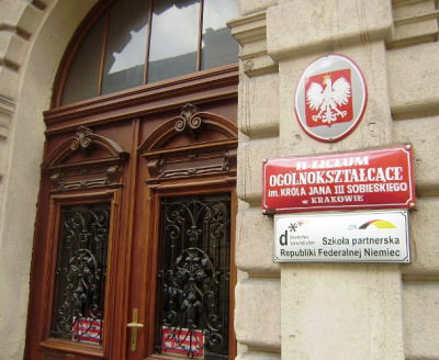 Kolorowa, współczesna fotografia. Przedstawia wejście do Liceum im. Jana III Sobieskiego w Krakowie. Szkoła do dzisiaj mieści się przy ulicy Sobieskiego.  