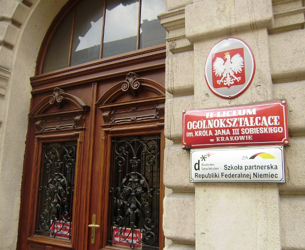 Kolorowa, współczesna fotografia. Przedstawia wejście do Liceum im. Jana III Sobieskiego w Krakowie. Szkoła do dzisiaj mieści się przy ulicy Sobieskiego.  