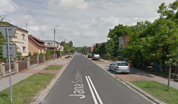 Współczesne zdjęcie. Przedstawia widok na ulicę w małym mieście. Jest to Ulica Jana Sobieskiego w Lesznie. 