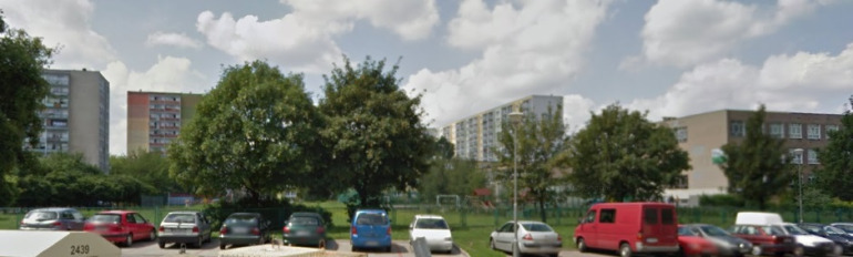 Współczesne zdjęcie. Na pierwszym planie parking i samochody. Na drugim planie bloki i drzewa. Osiedle Jana III Sobieskiego w Poznaniu.