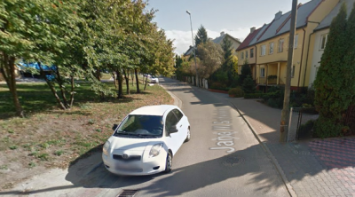 Współczesne zdjęcie. Przedstawia widok na małą ulicę wraz z zabudowaniami po prawej stronie. Na pierwszym planie biały samochód. Jest to Ulica Jana III Sobieskiego w Rawie Mazowieckiej. 