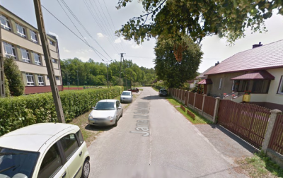 Współczesne zdjęcie. Przedstawia widok na miejską ulicę wraz z zabudowaniami. Jest to Ulica Jana III Sobieskiego w Trzebini. 