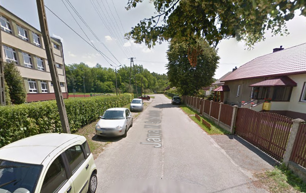 Współczesne zdjęcie. Przedstawia widok na miejską ulicę wraz z zabudowaniami. Jest to Ulica Jana III Sobieskiego w Trzebini. 