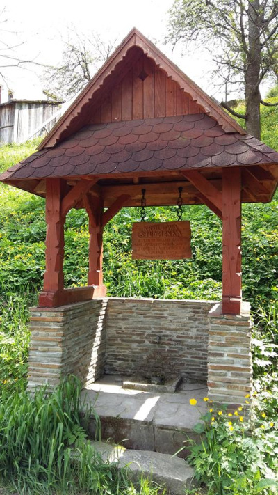 Współczesne zdjęcie. Przedstawia studnię „Królowa Studzienka”. Studnia znajduje się w pobliżu ulicy Sobieskiego w Piwnicznej-Zdroju. Wedle lokalnej tradycji wodę z tryskającego tu źródła pił król Jan III podczas powrotu spod Wiednia. 