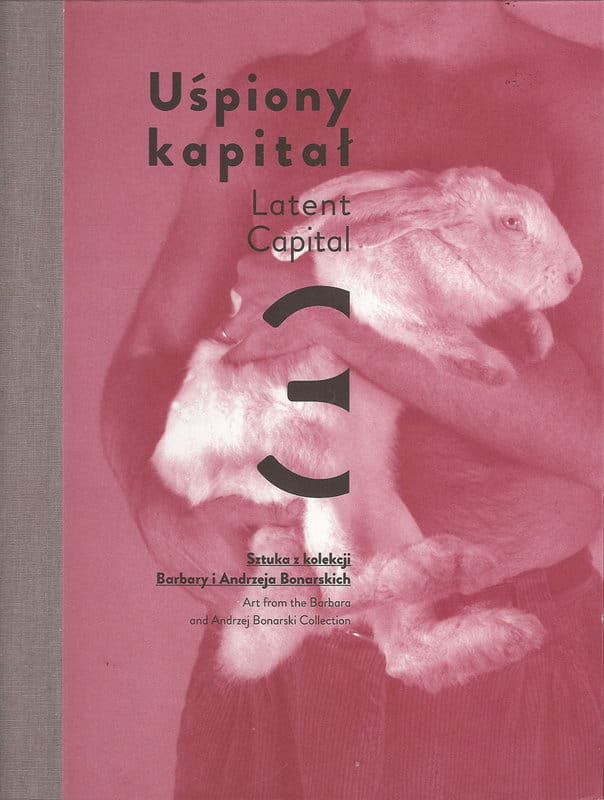 Okładka do książki "Uśpiony kapitał 3. Sztuka z kolekcji Barbary i Andrzeja Bonarskich". Przedstawia mężczynę trzymającego na rękach zająca lub królika. 