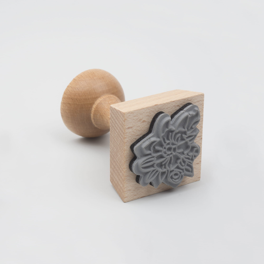 Drewniany stempel z pieczątką w kształcie kwiatka. 